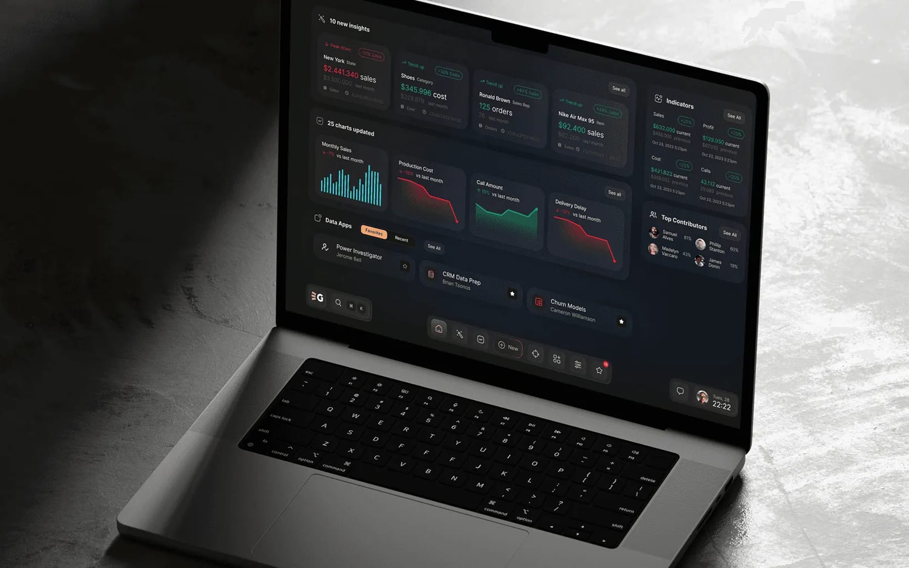 Open laptop on a concrete surface, showing a dark data dashboard with sales charts, indicators and top contributors